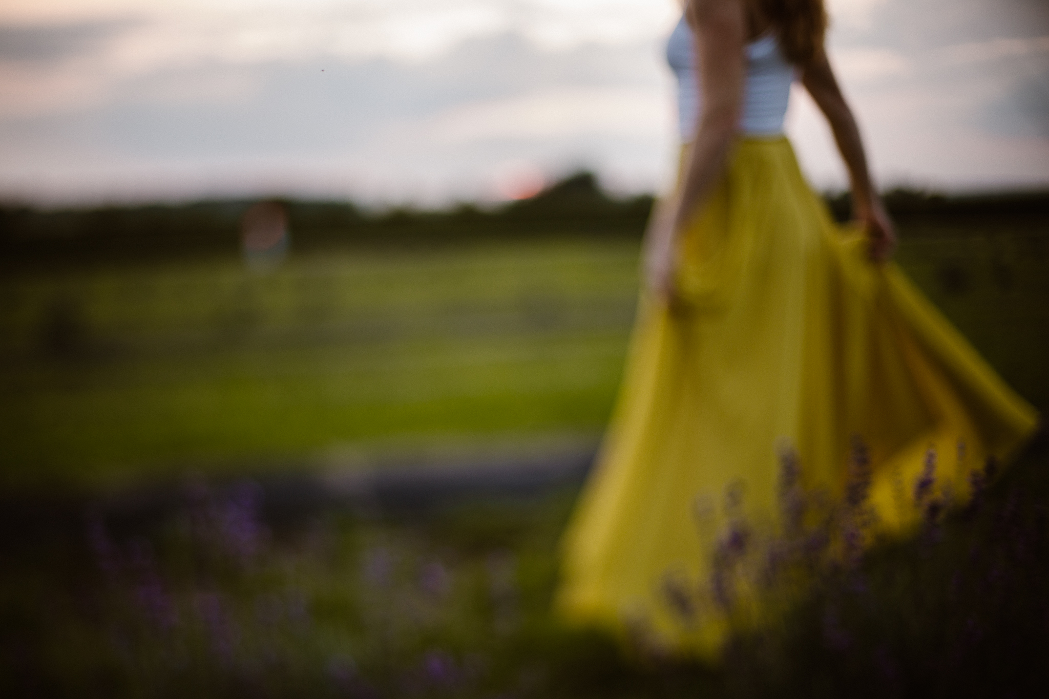 Red headed woman in yellow skirt at sunset in a lavender field.